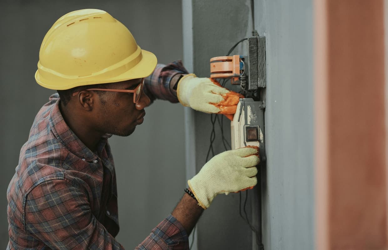 A technician working on a metered wall panel on site